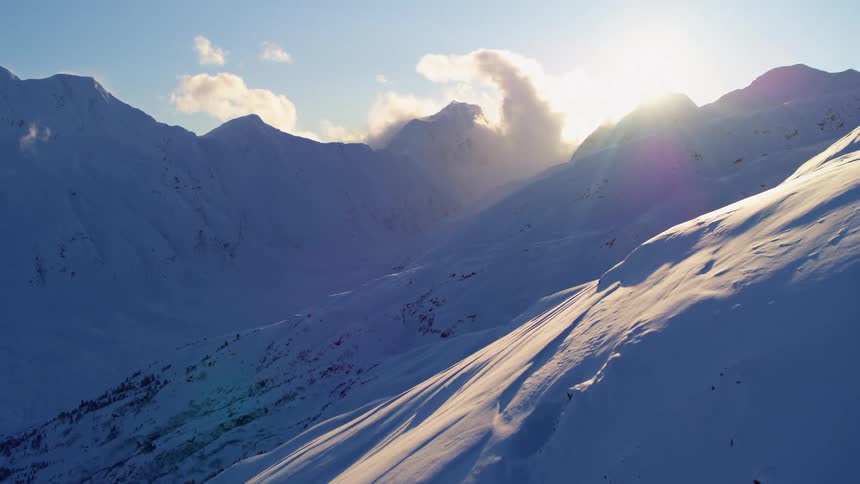 Snow covered mountains with a bright sun shining
