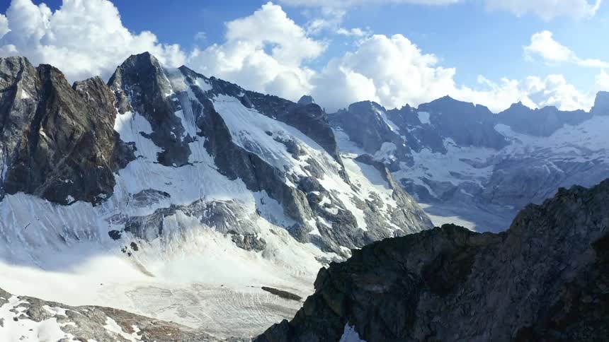 Sun shines on a snow covered valley between mountains