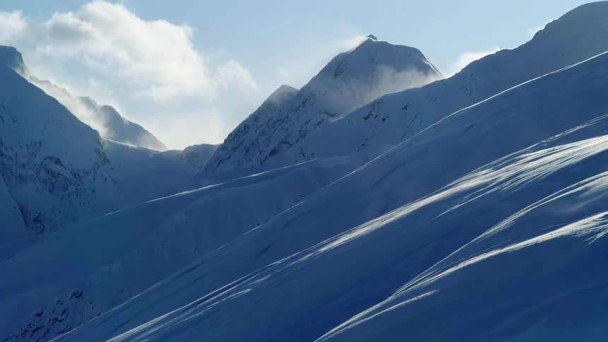 A snow covered mountain range with many slopes