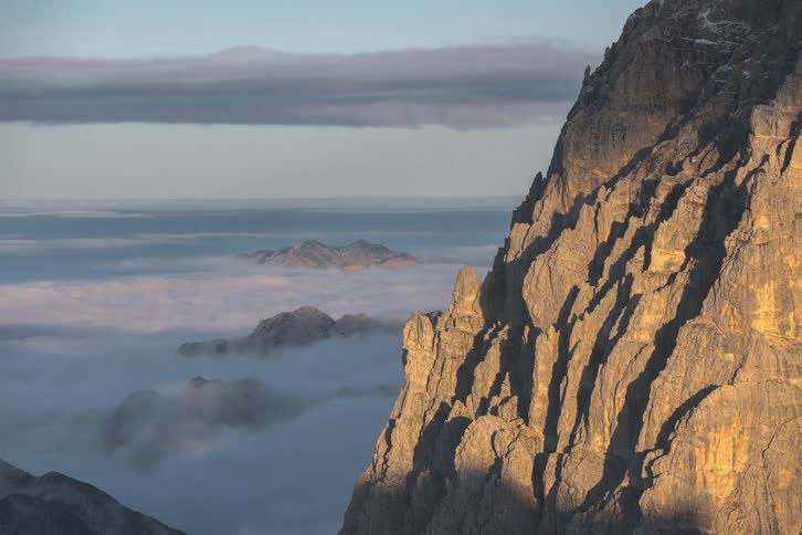 Rigged mountain side and view of mountain tops as the clouds move along in the sky and across the mountain tops