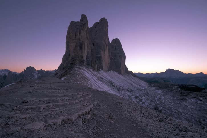 A small slope leads to a tall rock formation in a canyon