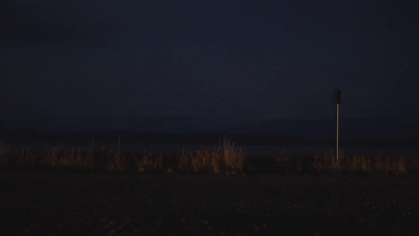 Cars driving on a road at night with their headlights on