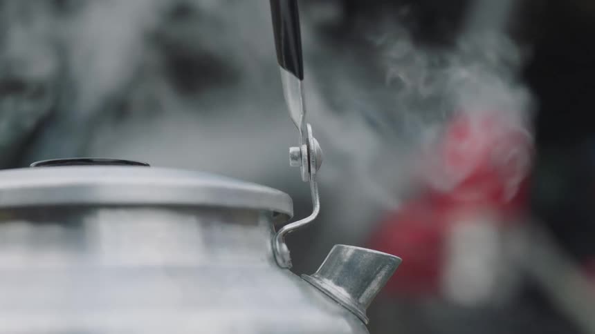 A kettle outside with steam coming out of it