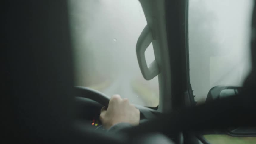 Person driving a car through foggy condition