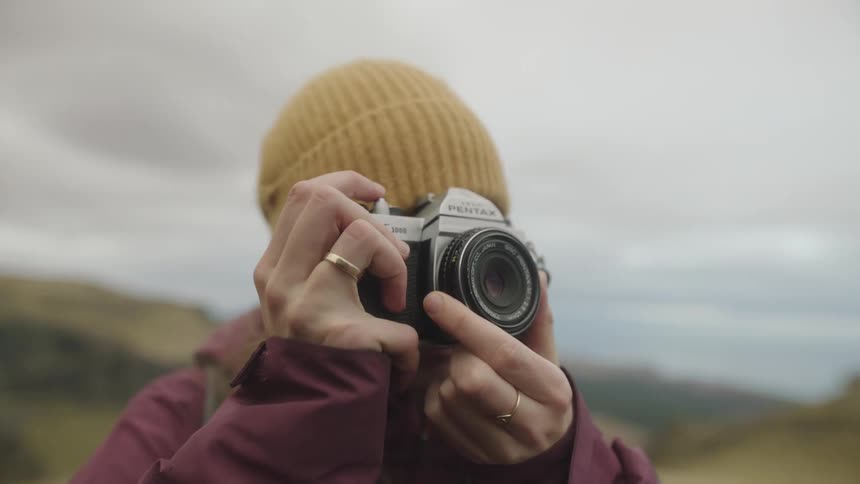A person takes a picture while adjusting the focus on the camera on a cold day