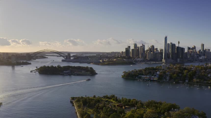 Wide shot of a city with buildings water bridge and a boat on a sunny day