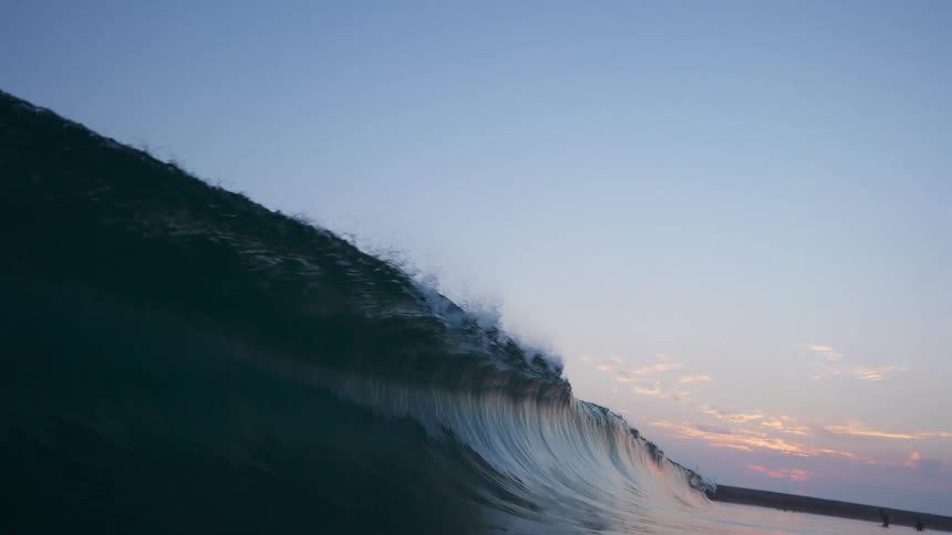 A large rolling ocean wave curls and breaks