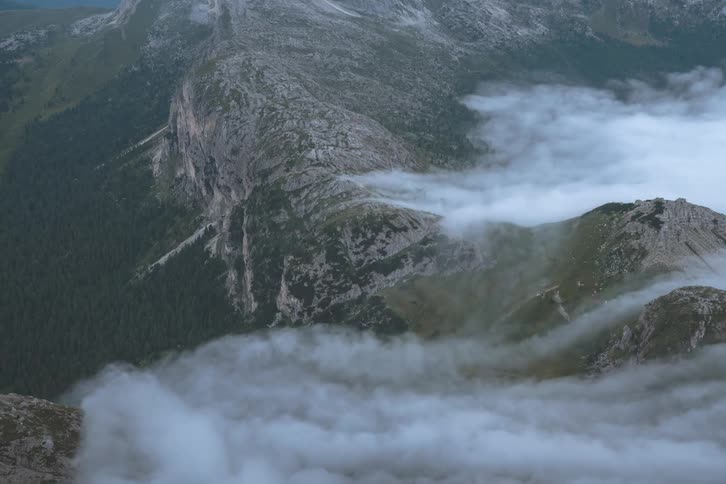 Time lapse of clouds pouring over the tops of mountains