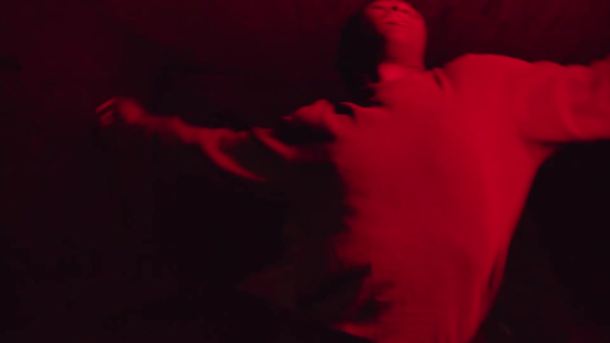Boy dancing wildly in a tunnel underpass at night with flashing red lights