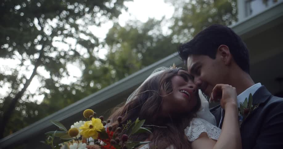 A bride and groom kiss outside their wedding venue