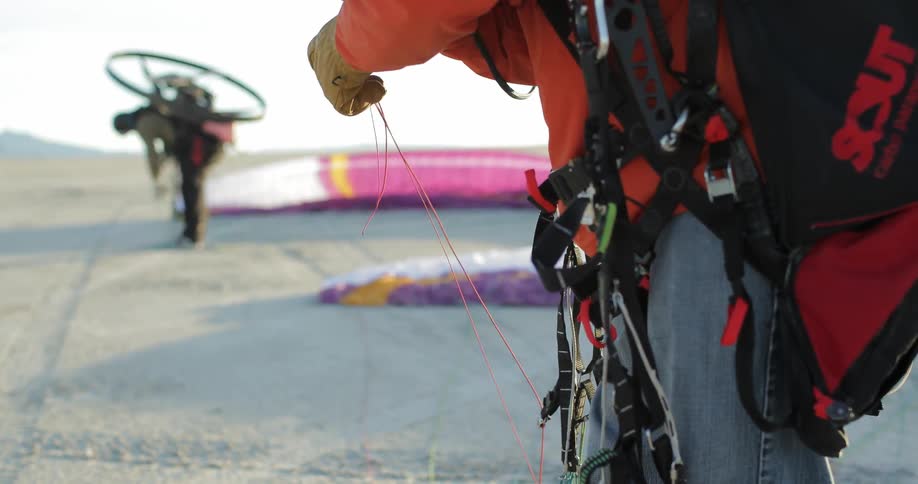 A man is tying string to a harness