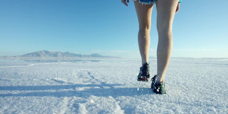 Person in shorts walking across a desolate plain