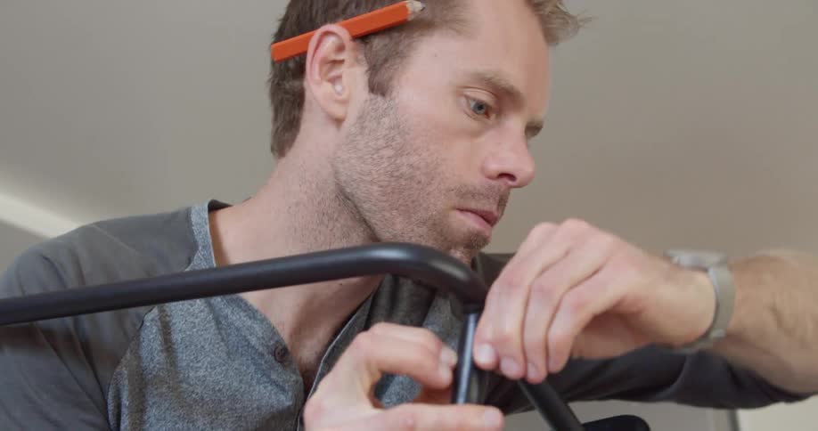 A man assembles furniture inside