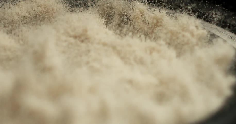 A white powder in a pan vibrating and shaking