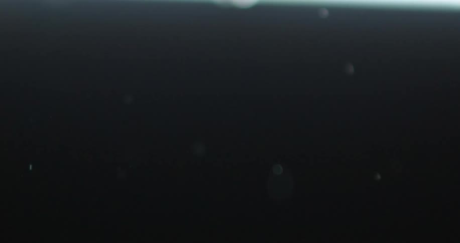 Brown liquid splashing around on a black surface