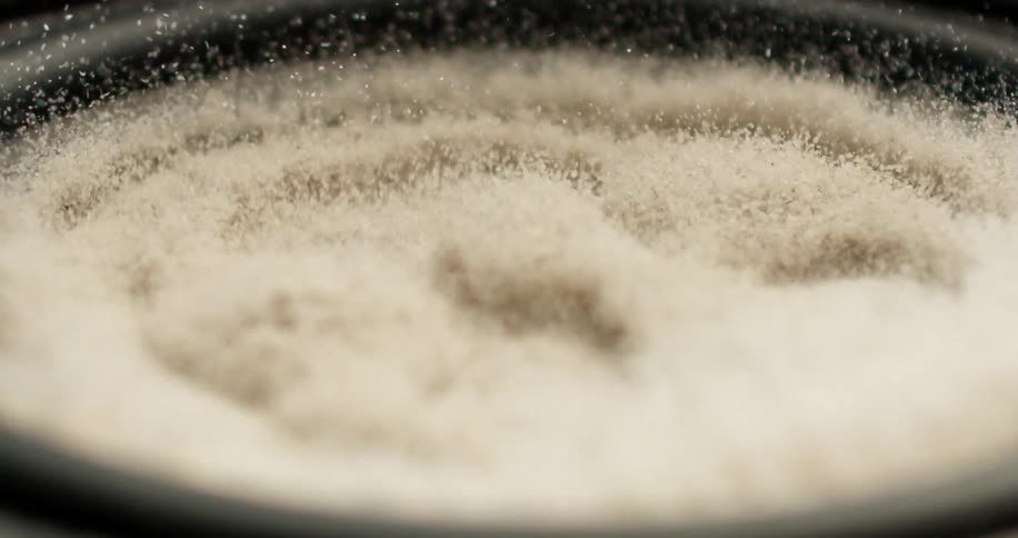 White granules moving with vibrations from the surface