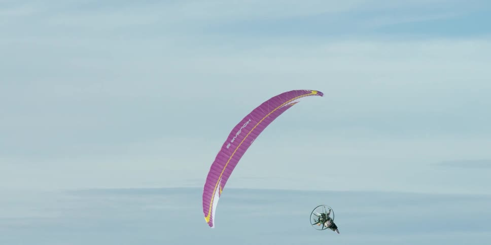 Person paragliding with a fan powering them