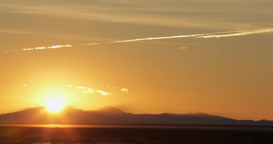 An orange colored sky with the sun setting