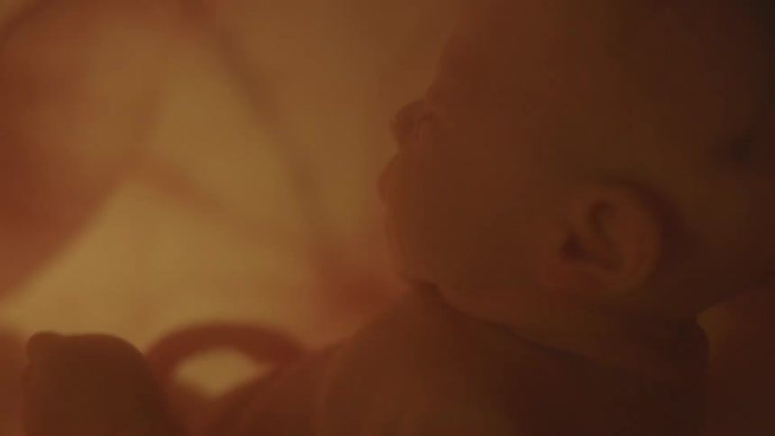 Baby with the umbilical cord connecting the baby to its mother in mothers womb