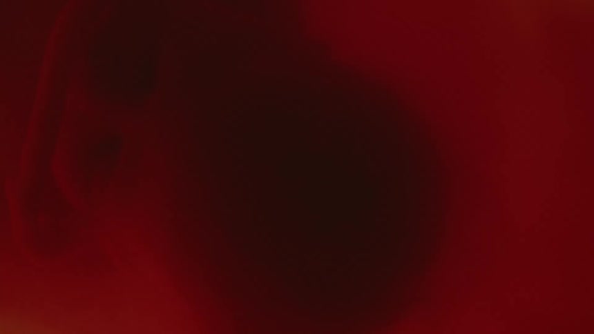 A babys face and arm in red blurry atmosphere