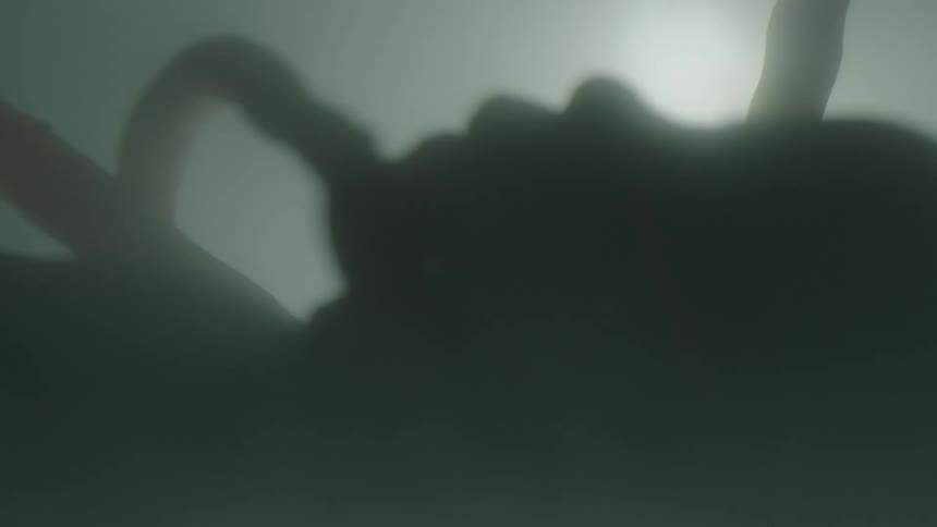 A profile of a baby with a cord in a gray setting