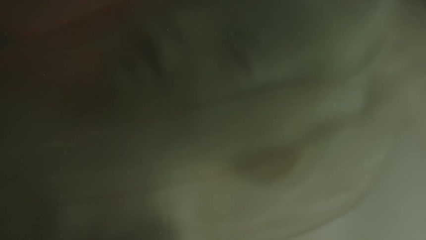 An unborn baby floats with face covered in membrane