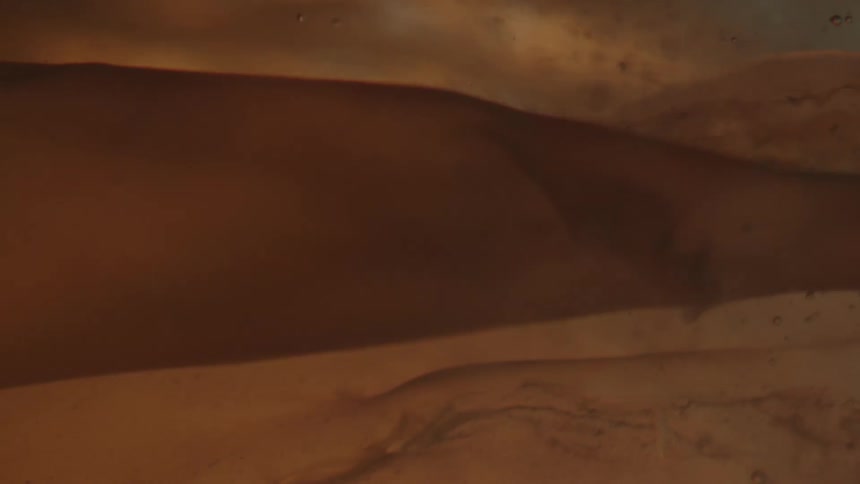 A gauzy object moves in liquid as light flashes in and out