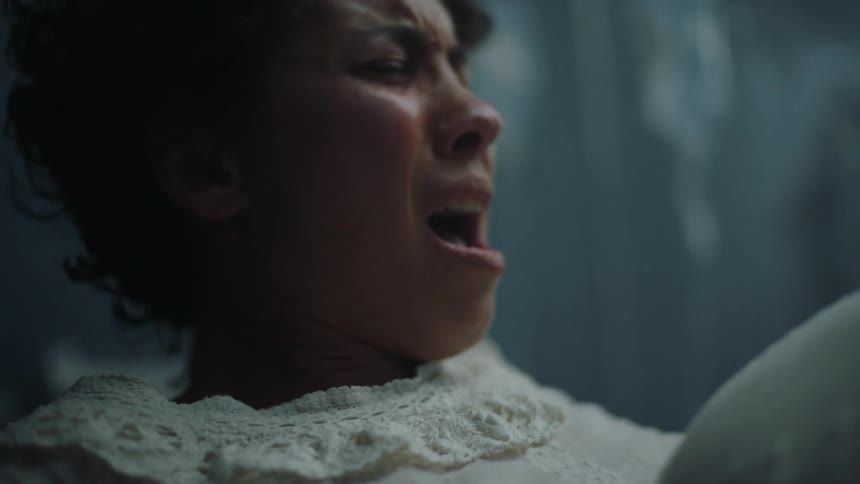 A woman screaming in pain while giving birth