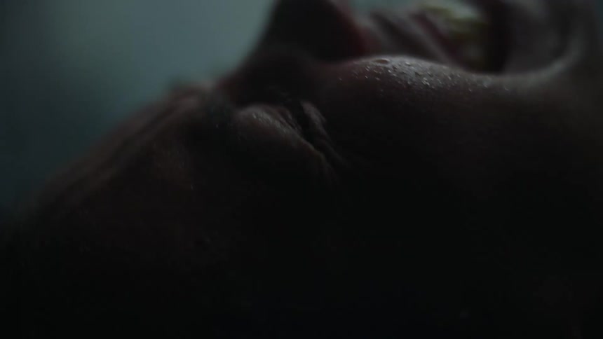 A woman strains and grits her teeth as she goes through labor