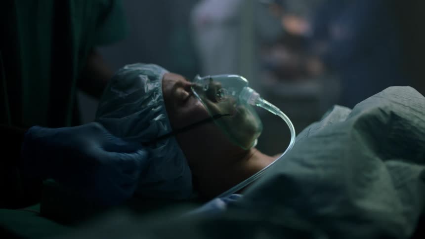 A medical professional places an oxygen mask on a scared female patient