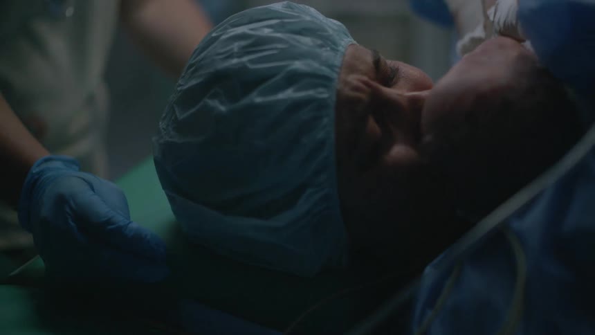 Mother with a surgical round bouffant cap holds the newborn baby and cries tears of joy in the hospital