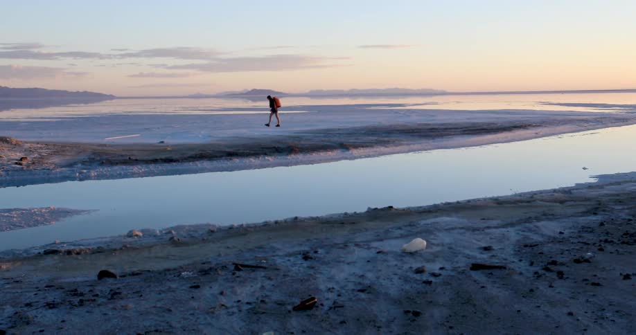 Person hiking across a flat area of bare land