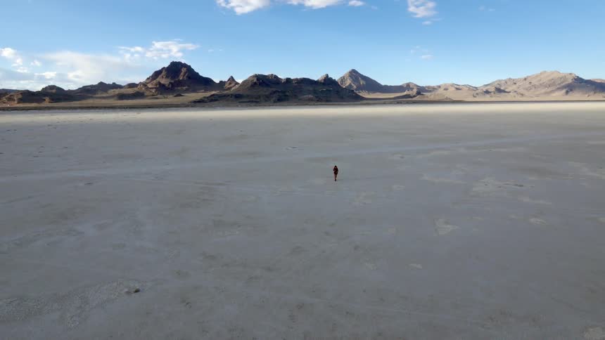 Person walking across a barren plain