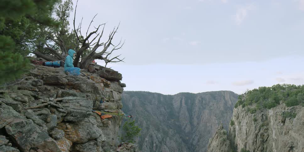 A person is sitting on top of a mountain