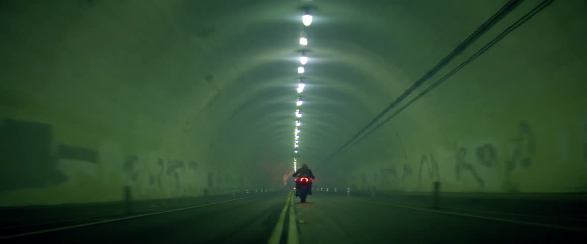 A person on a motorcycle drives through a tunnel
