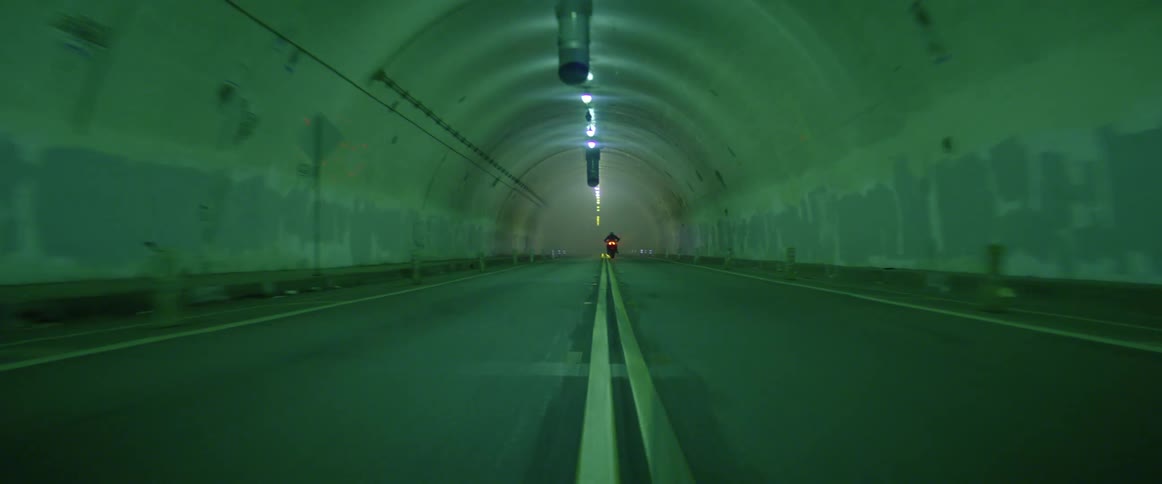 A person is riding a motorcycle through a tunnel