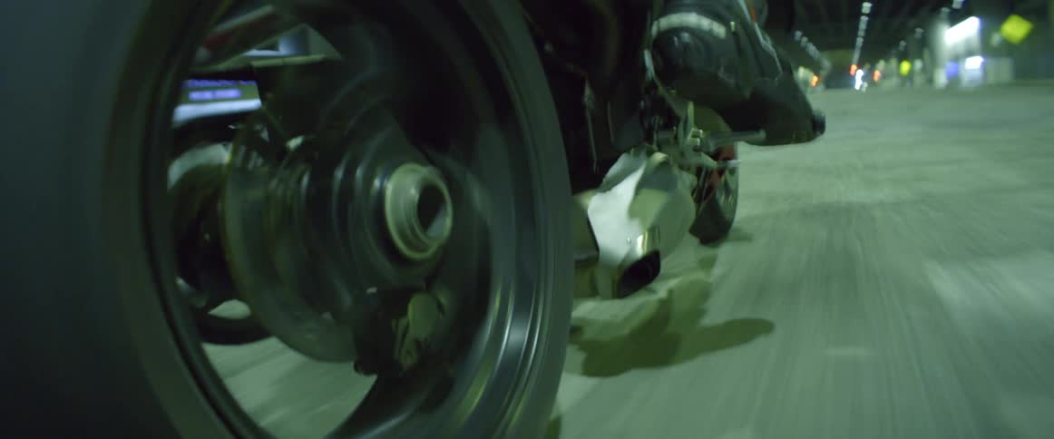 A person is driving a motorcycle at night