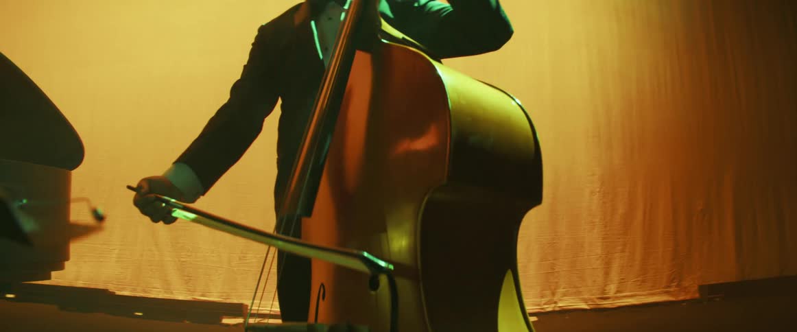A male musician readies to play his instrument on stage indoors