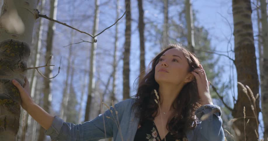 A woman is walking through a forest
