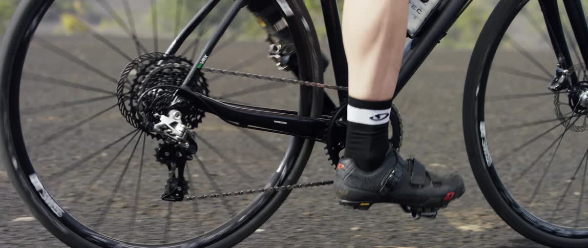 side close up tracking shot of a gravel bike drivetrain in motion
