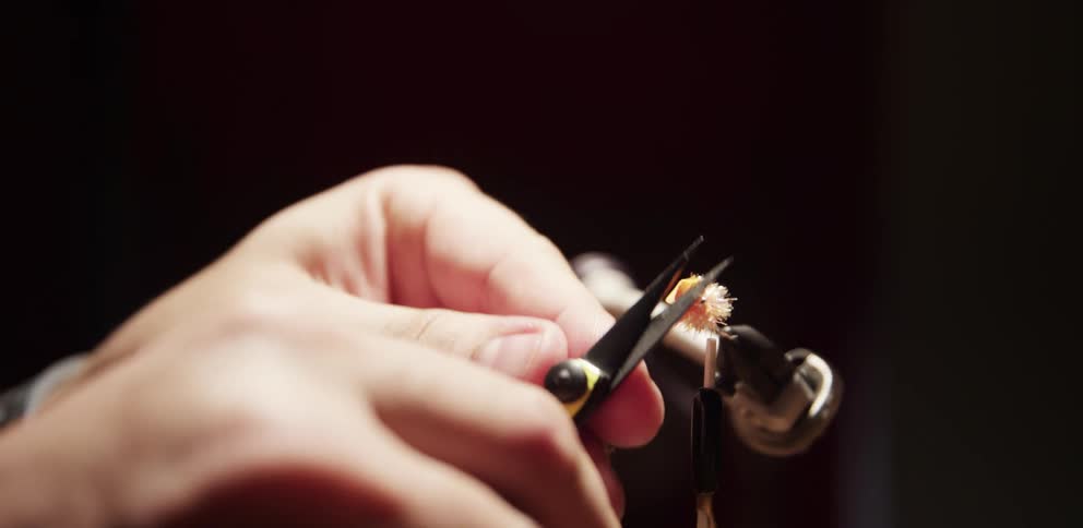 A man uses small scissors to cut some plastic