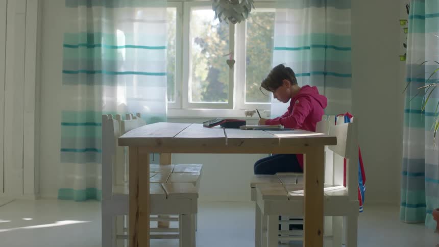 A young boy does school work at home