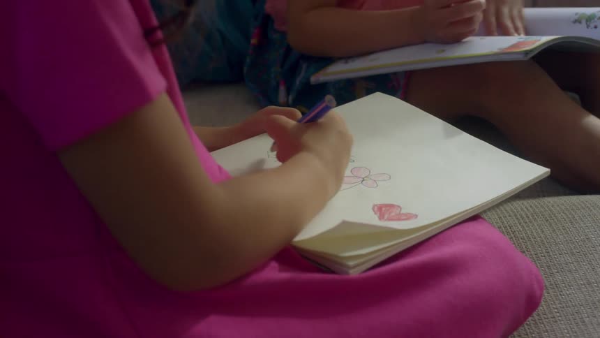 Two children color together
