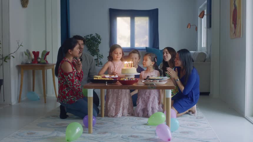 Family and friends celebrating a little girls birthday at home