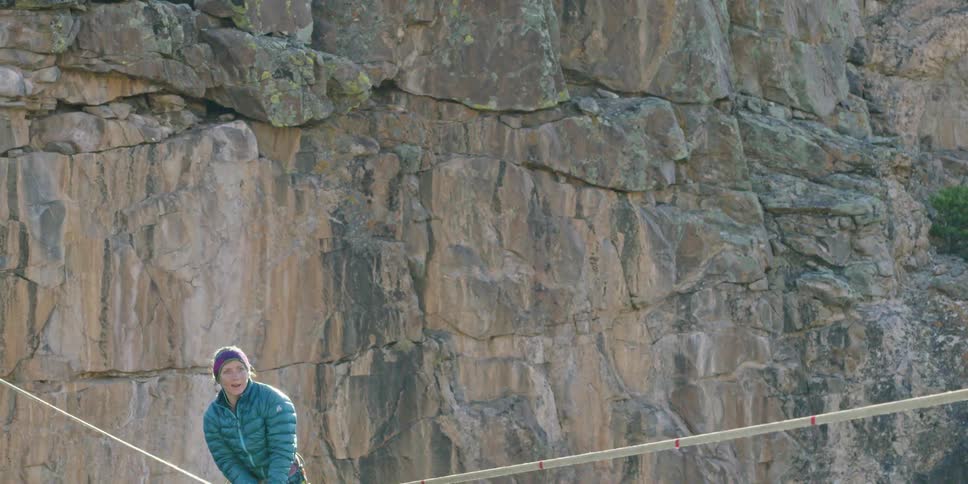 A woman falling as she attempts to walk a tightrope