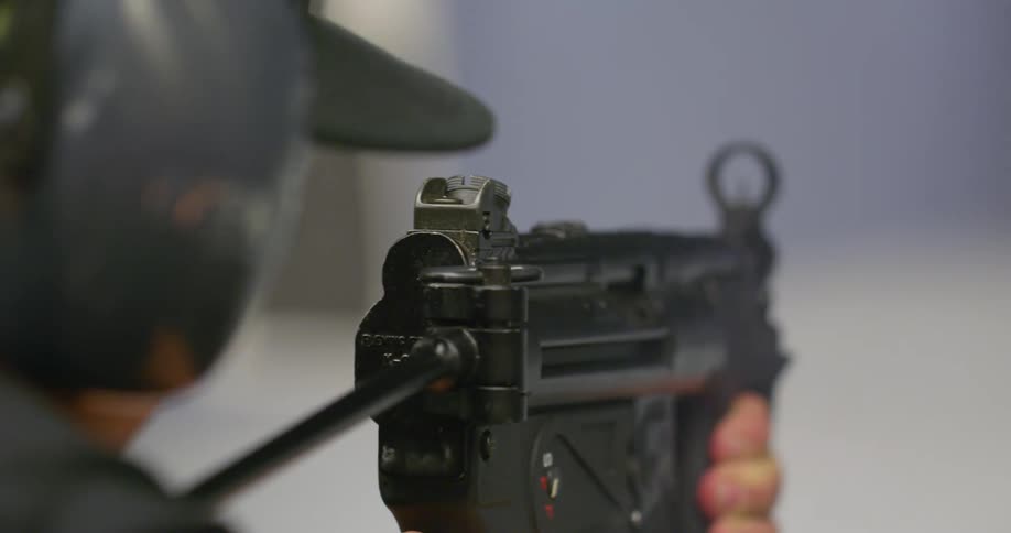 A person shoots a gun with a sight on it