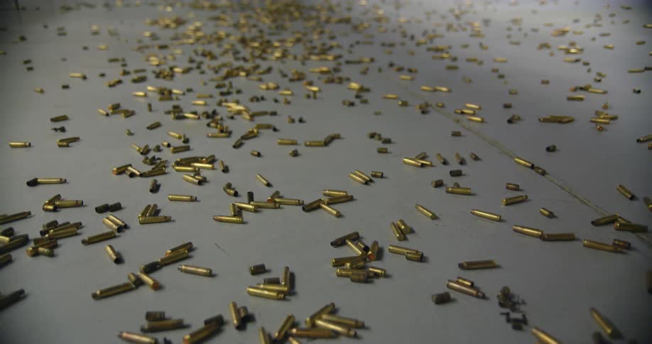 Pile of bullet casings scattered on a gray flooring