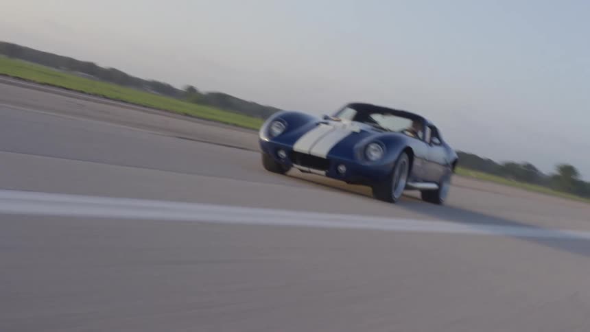 A man is driving a car on an empty road
