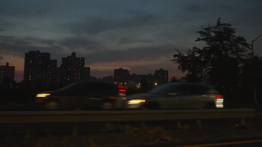 Heavy traffic on the freeway passes by downtown skyscrapers