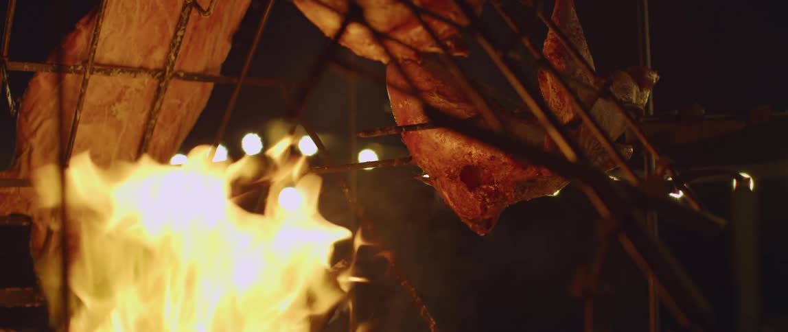 A fire in front of a tent at night